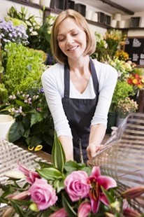 Woman working at flower shop smiling